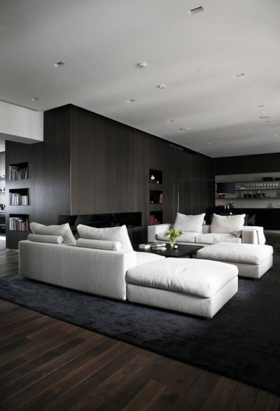 Tasteful, masculine and clean arrangement of this pair of sectional sofas and ottomans in white on black. Very chic and comfortable for entertaining and conversation.